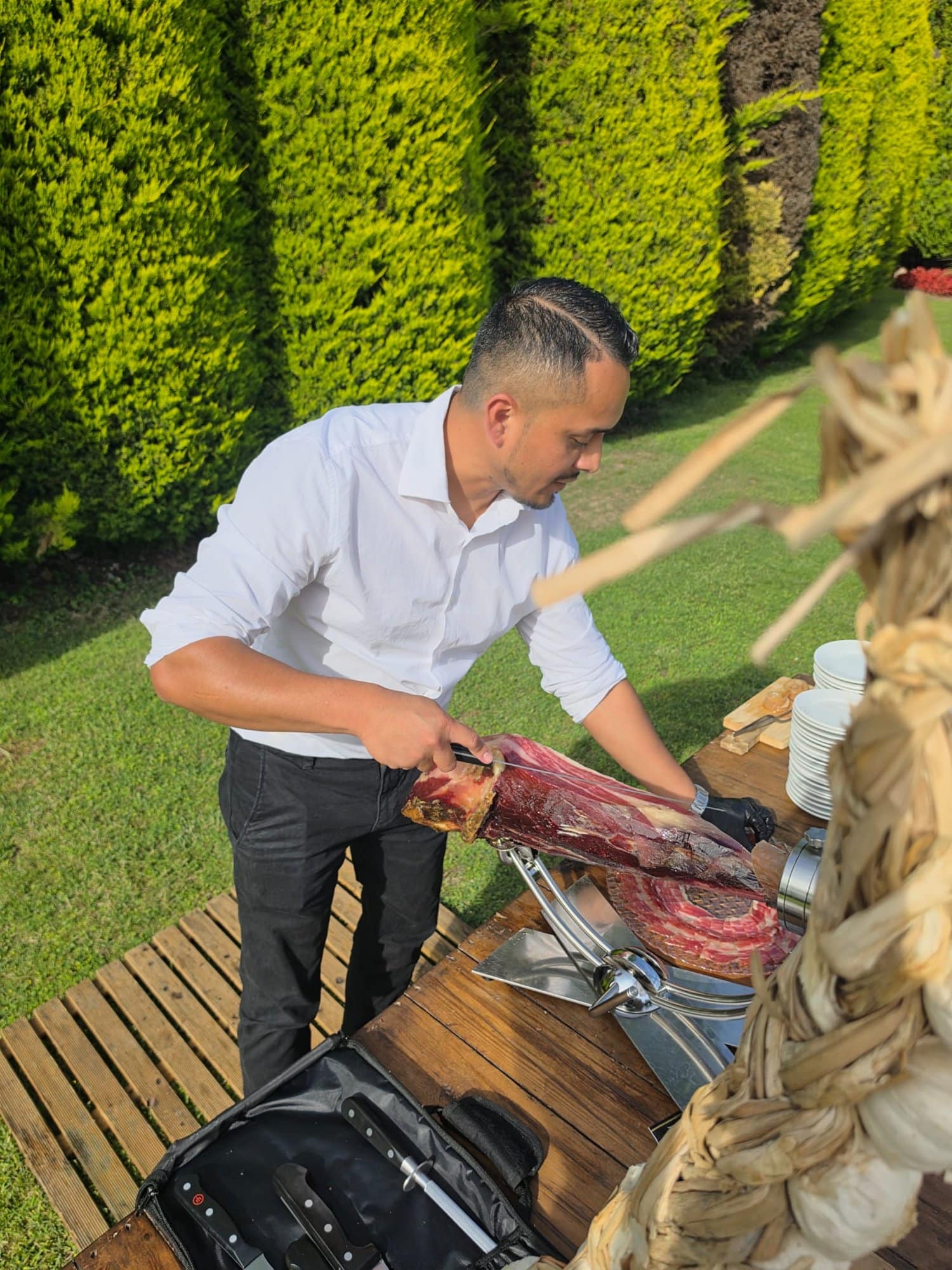 Jeffrey Rodríguez cortando jamón ibérico en el jardín de una boda