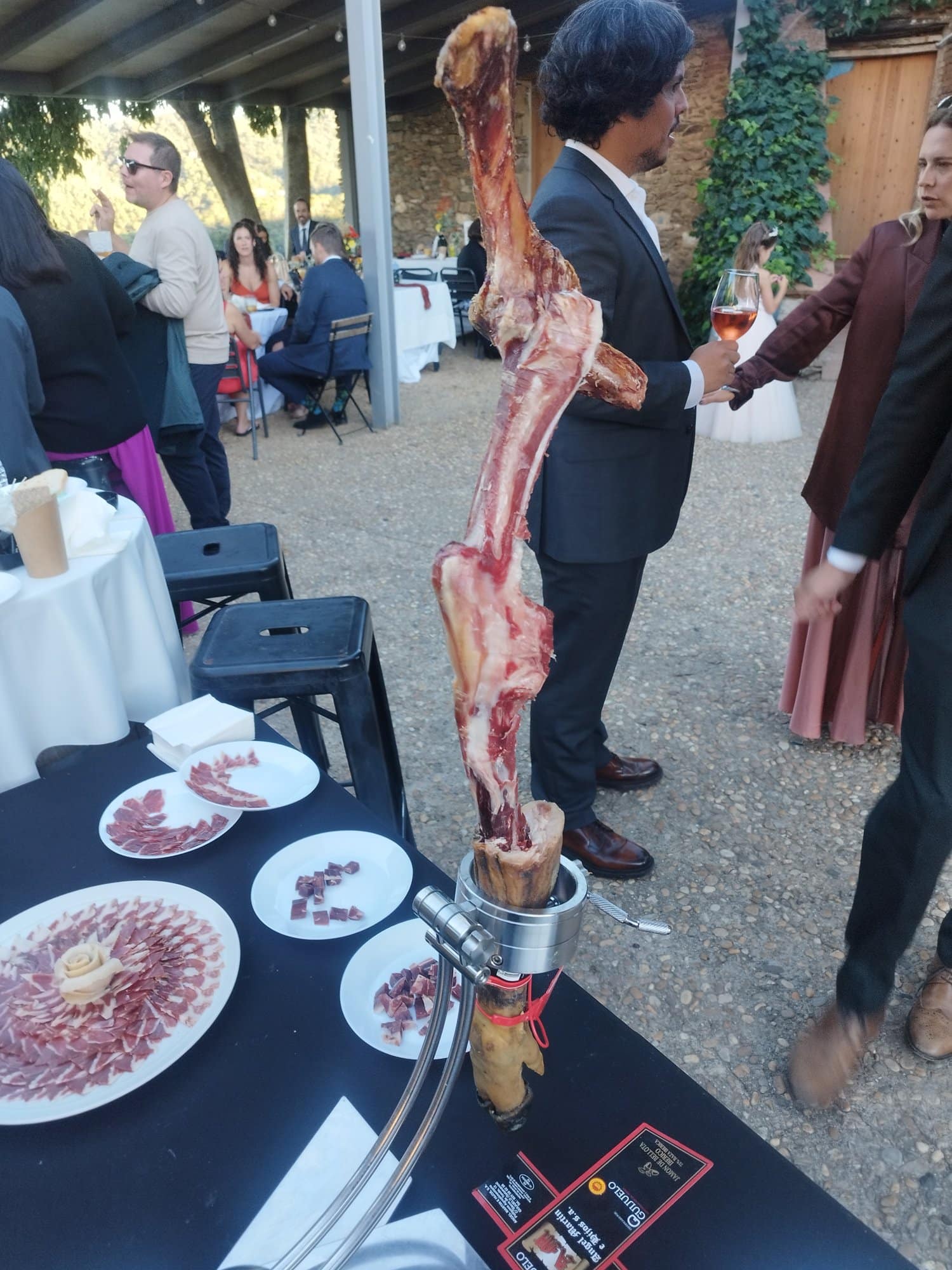 Invitados de boda junto a la estación de jamón
