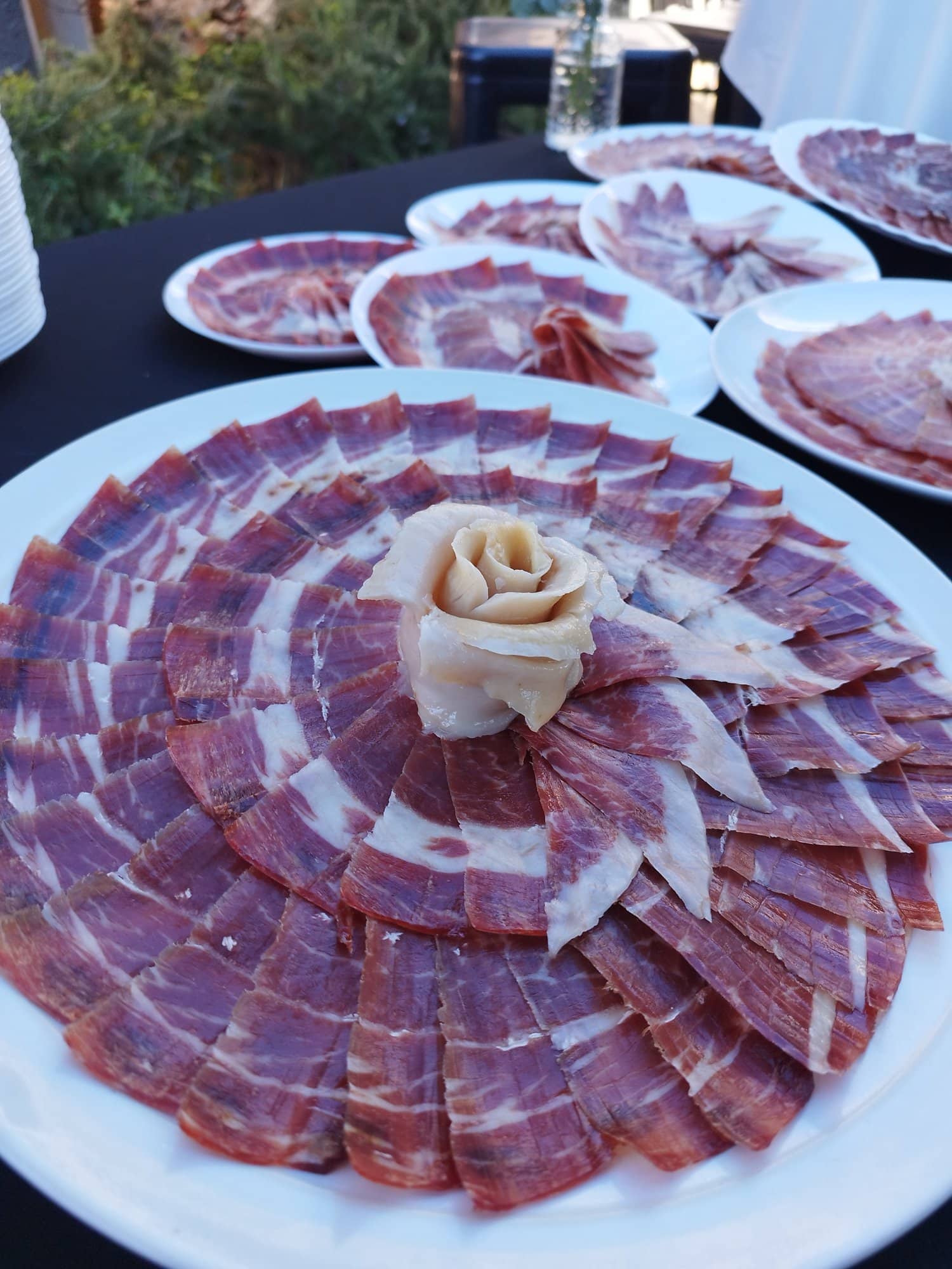 Plato de jamón ibérico emplatado con rosa