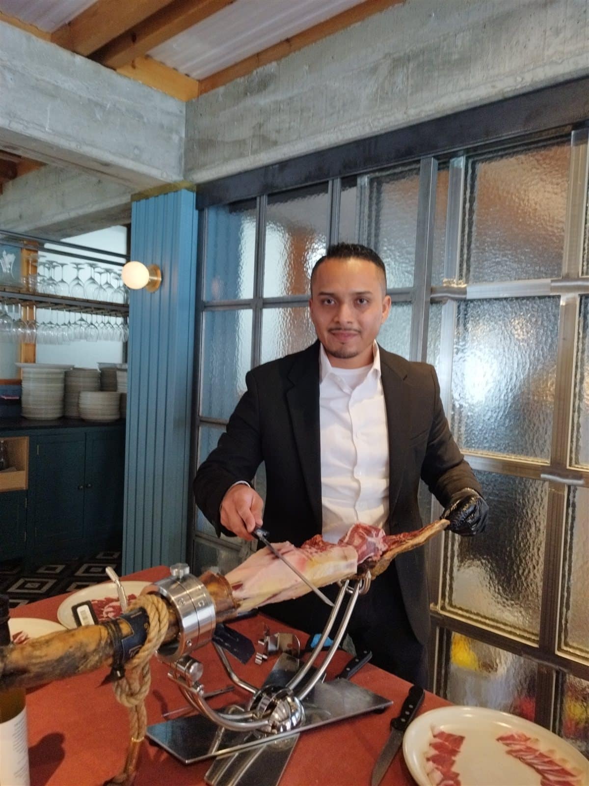 Cortador de jamón profesional cortando jamón ibérico en directo en un evento gourmet