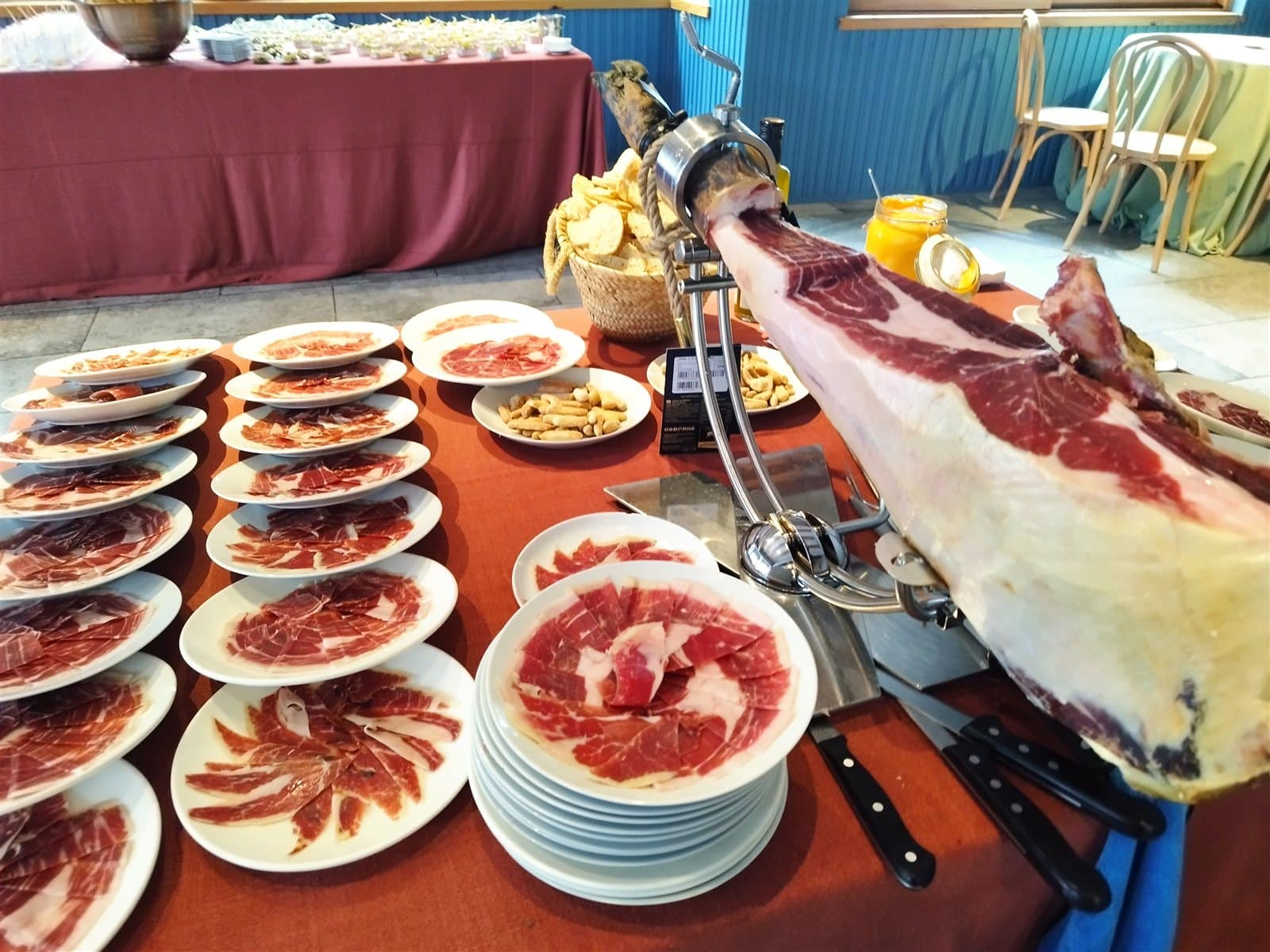 Estación de corte de jamón con platos listos para servir en un evento