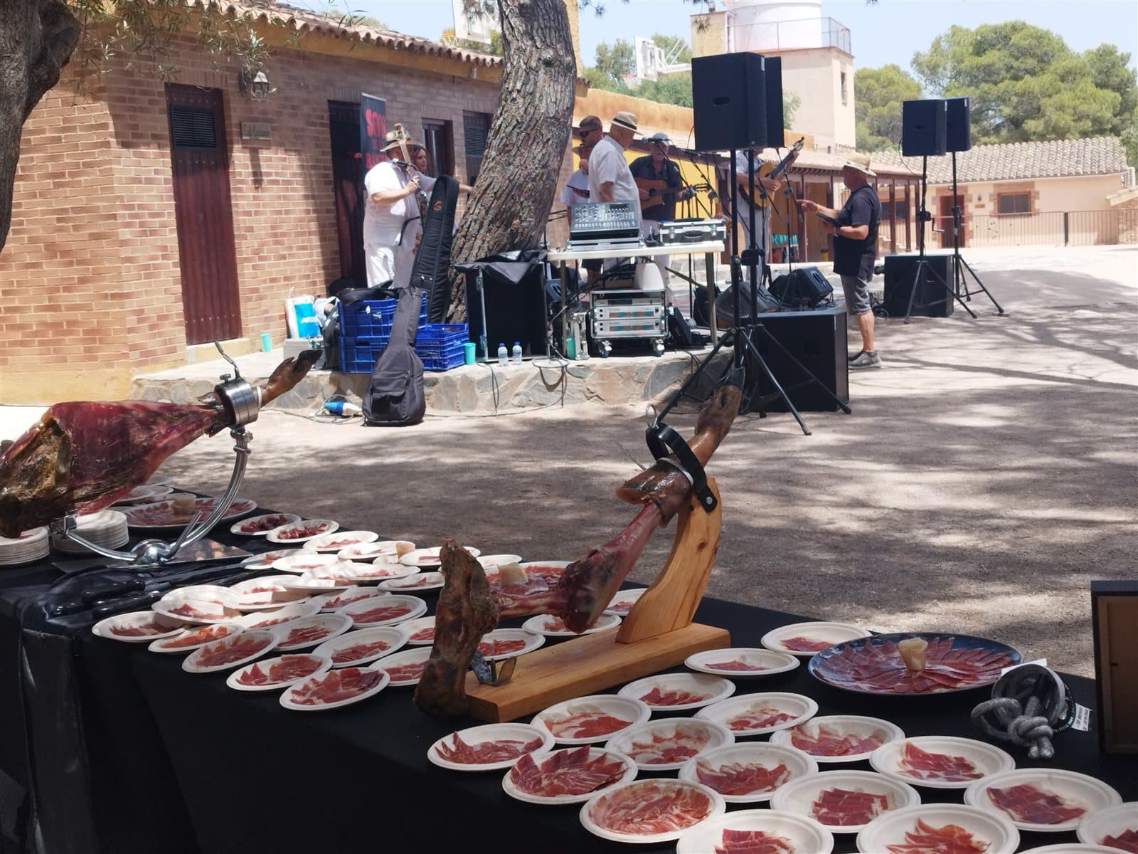 Estación de jamón ibérico en una celebración al aire libre con música en directo