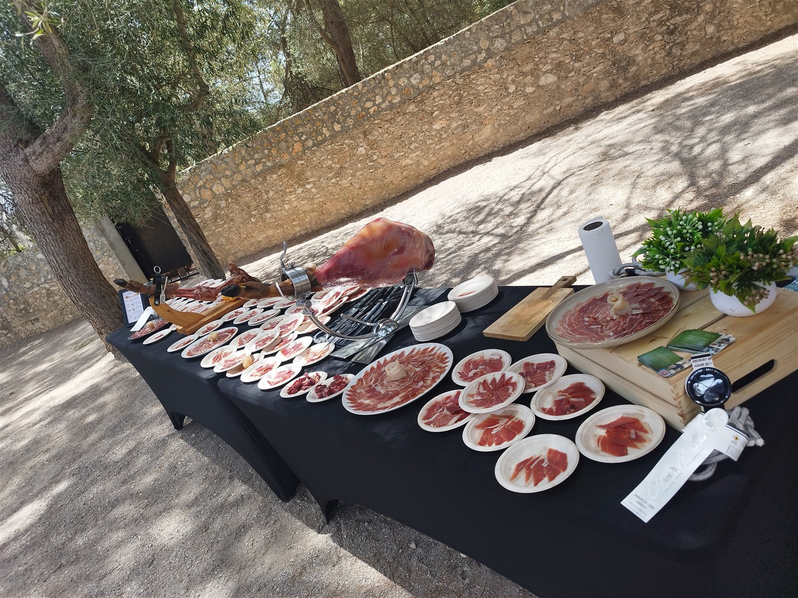 Mesa de jamón ibérico al aire libre preparada para una celebración privada
