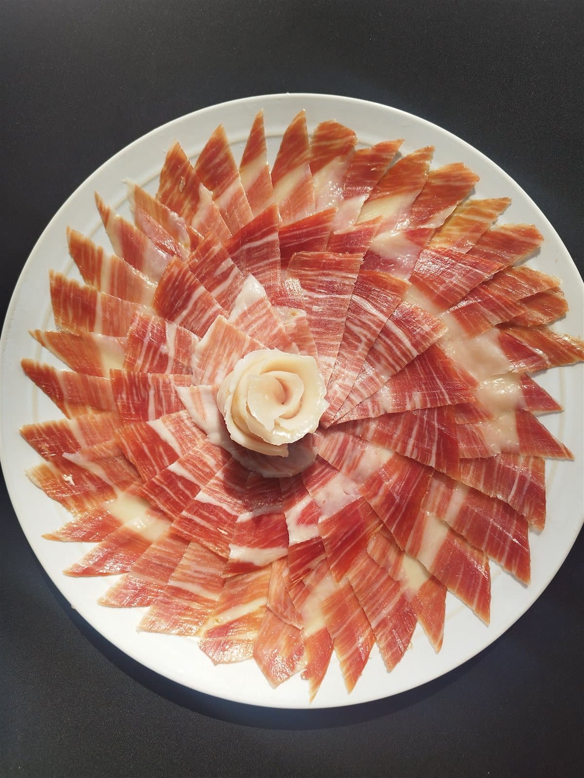 Plato de jamón ibérico emplatado en forma de flor