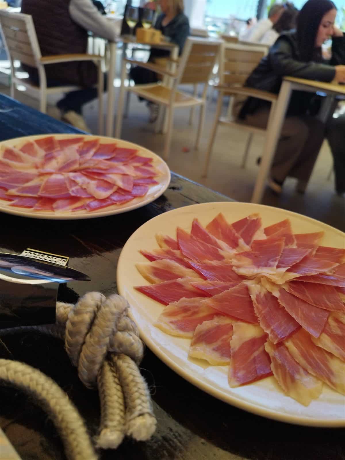 Platos de jamón ibérico servidos en una terraza durante un evento